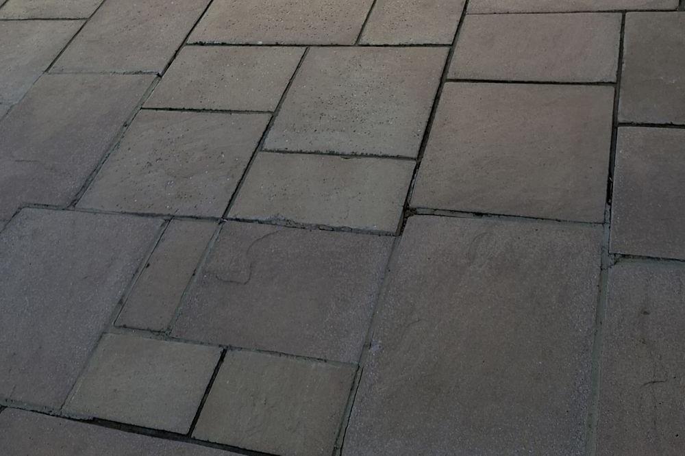 The same patio after pressure washing, with the stone colour restored
